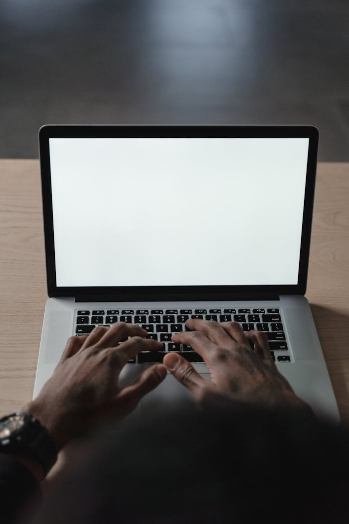 services-02 Hands typing on a laptop with a blank screen, perfect for mockup or design use.
